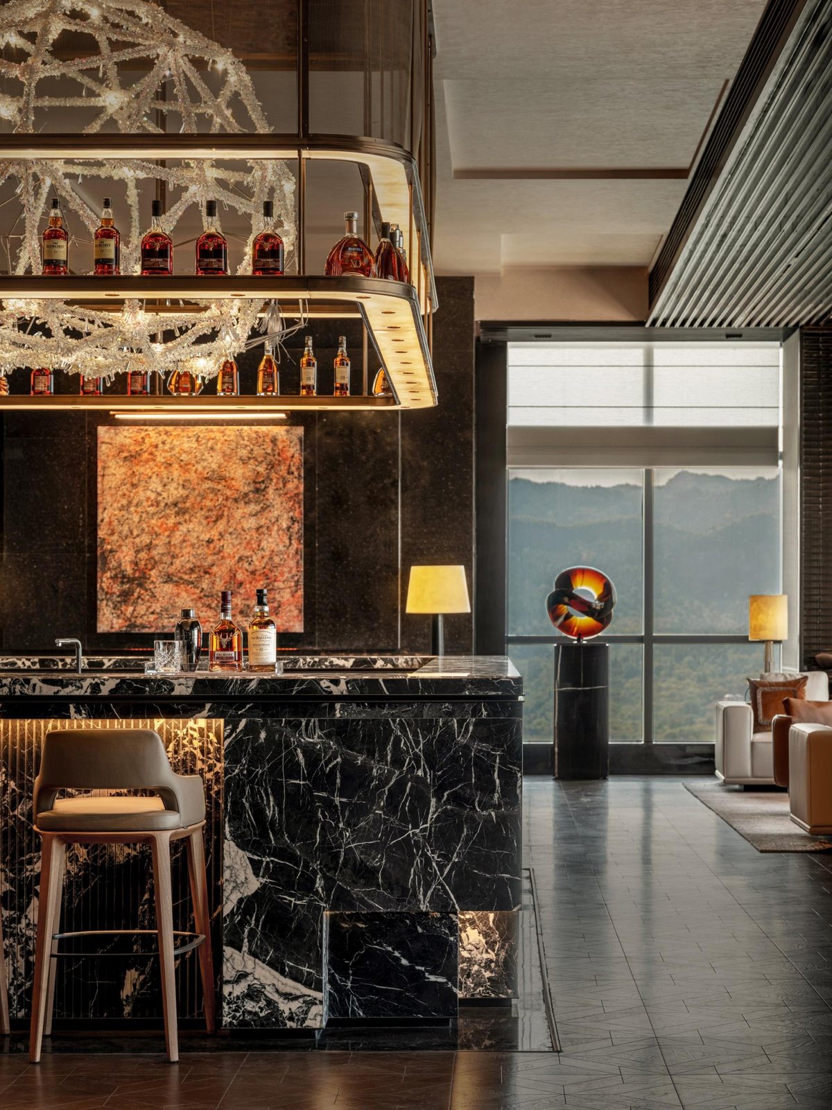 Hospitality bar counter with dark stone, warm shelving and high seating