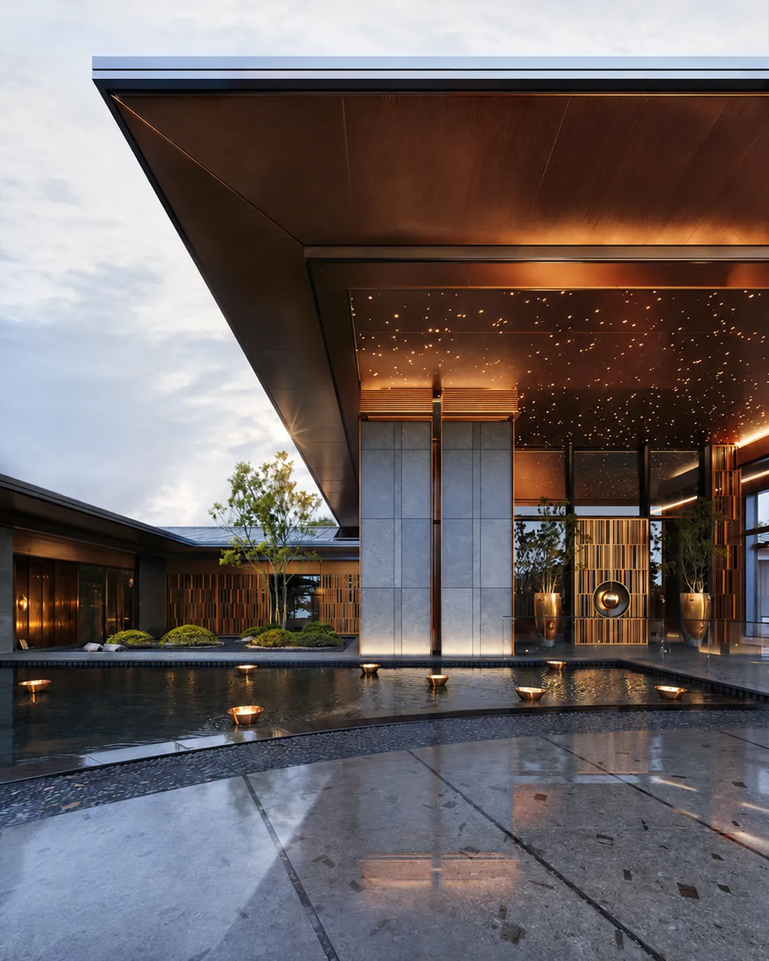 Contemporary residential entrance with a reflecting pool, stone pillars and warm soffit lighting