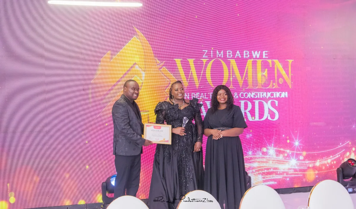 Ivy with a trophy beside two presenters holding a certificate at the Zimbabwe Women in Real Estate and Construction Awards