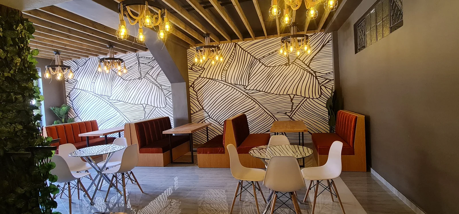 Mr Sadza Eastgate dining interior with patterned wall panels, upholstered seating and warm pendant lighting.