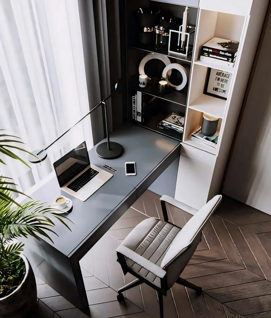 Study nook with a fitted grey desk, open shelving, a laptop, task lighting and a cushioned chair.