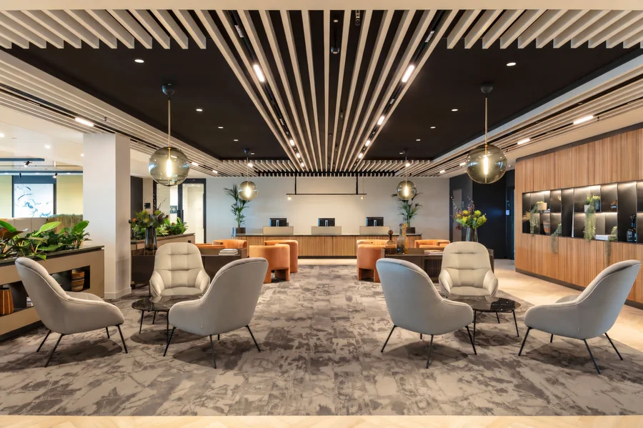 Corporate reception with warm timber ceiling slats and comfortable visitor seating