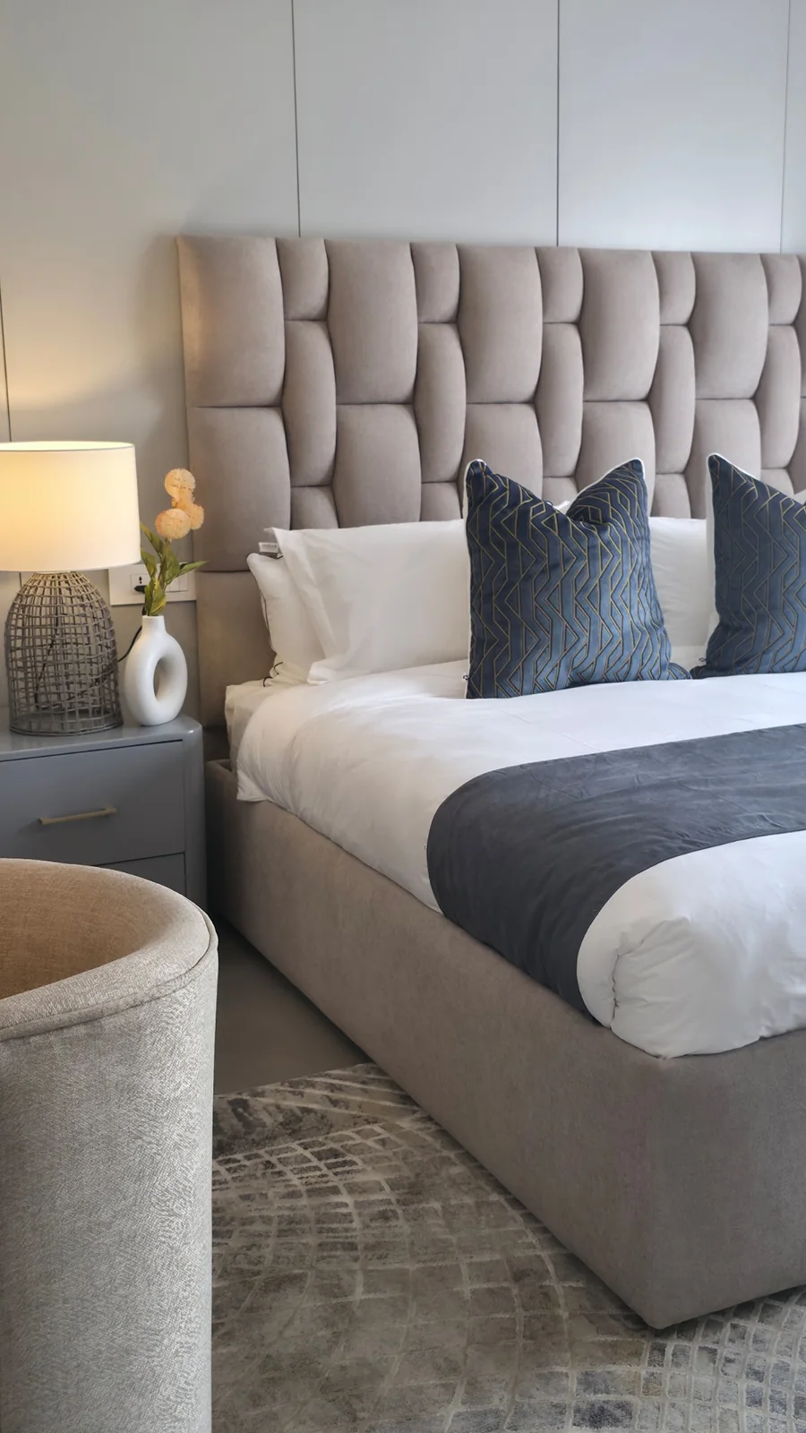 Esfog Lodge, Kadoma: bedroom with a tufted headboard, layered bedding and a bedside lamp