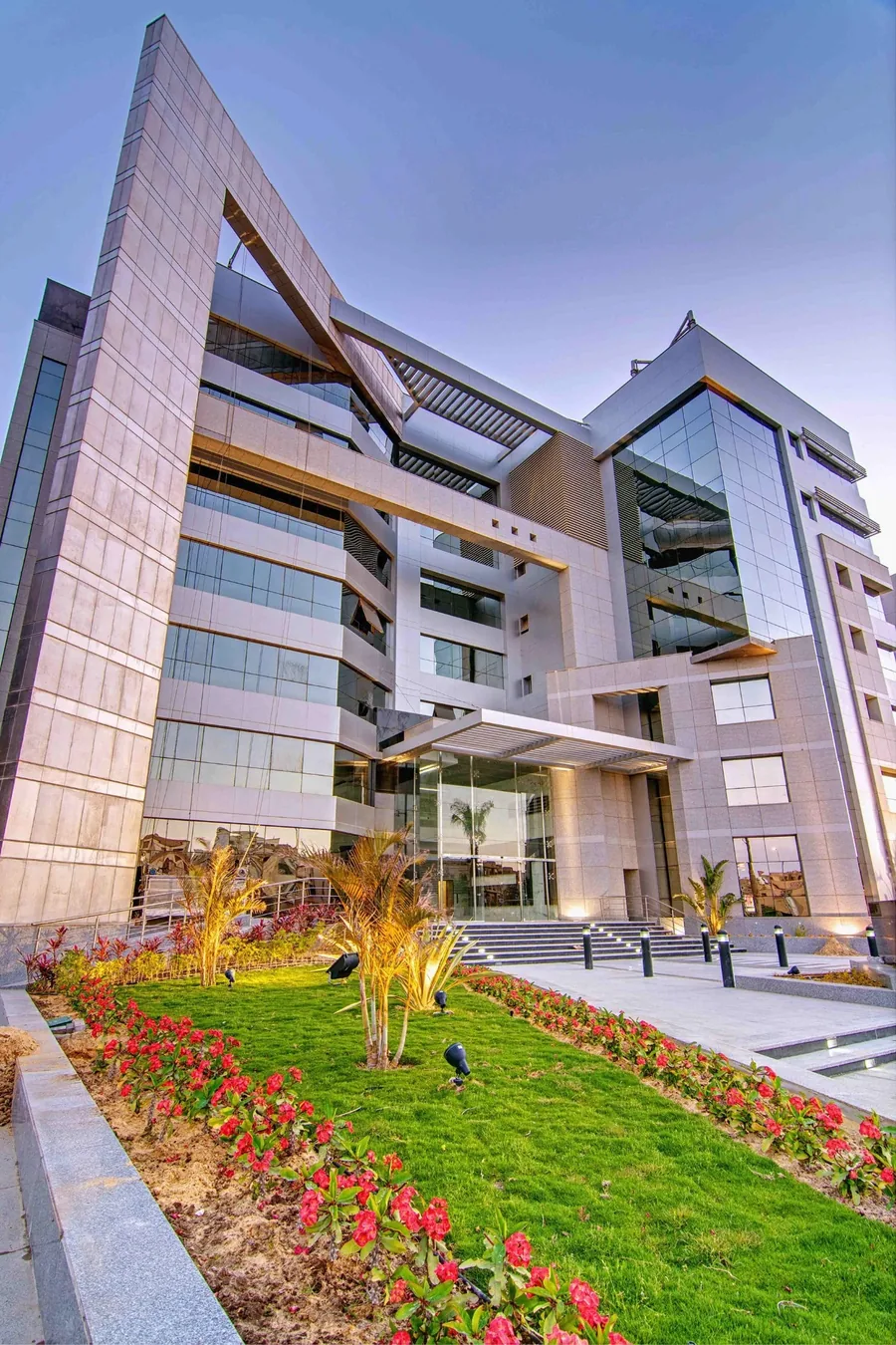 Multi-storey building with angled roof forms and landscaped surroundings